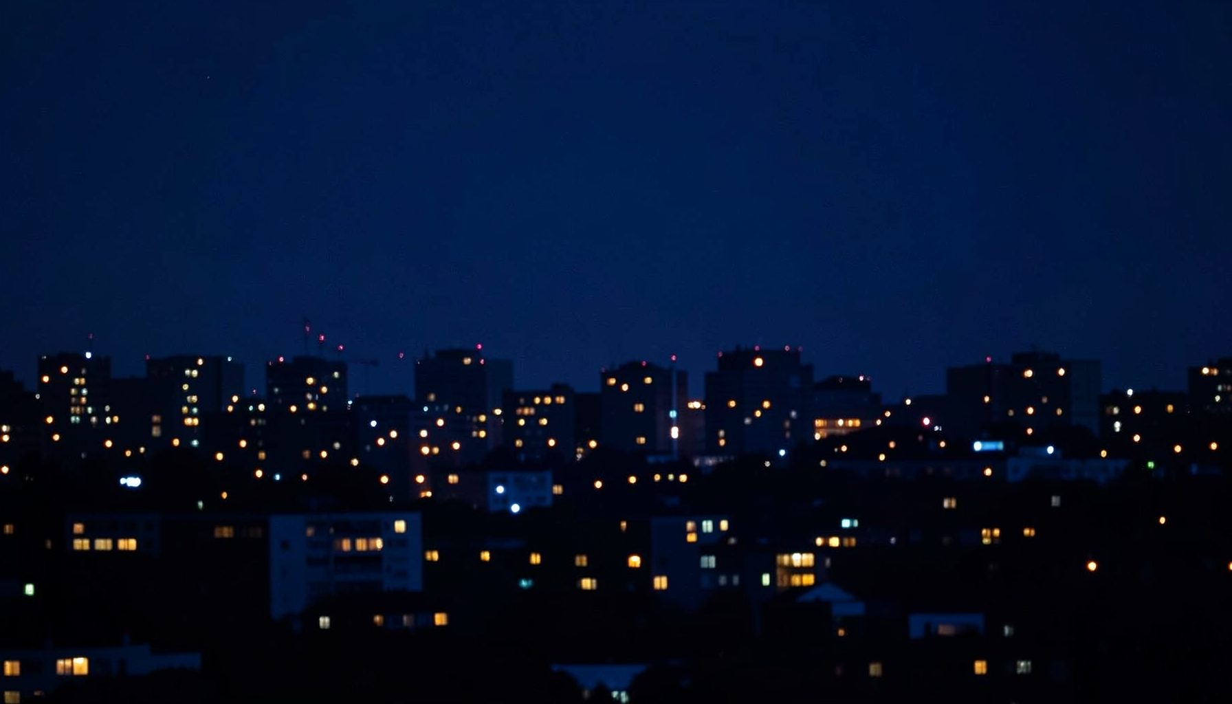 Deep navy blue night skyline with scattered warm window lights, conveying a serious and trustworthy news atmosphere